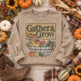 Gather & Grow DTF transfer with vintage sign-style lettering, sunflower, and wire basket overflowing with corn, tomatoes, peppers and squash Shown on a Sand crewneck sweatshirt.