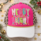 Merry and Bright Christmas DTF transfer with bold candy-colored patterned block letters outlined in gold glitter and colorful string lights Shown on a hot pink front panel with white bill and leopard print mesh back trucker hat.