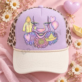 Pastel airbrushed horror clown face DTF transfer peeking through daisies with yellow raincoat, heart balloons, and S.S. Georgie paper boat Shown on a dusty lavender front panel with cream bill and leopard mesh back trucker hat.