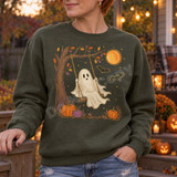 Cream-colored ghost swinging from a tree branch DTF transfer with glowing orange moon, bats, and autumn pumpkins Shown on a Military Green crewneck sweatshirt.