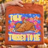 Talk Turkey To Me Thanksgiving DTF transfer with cartoon roasted turkey chatting on a retro telephone, surrounded by orange stars on a blue starred background Shown on a Yam t-shirt.