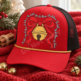 The Bell Rings For Those Who Believe Christmas DTF transfer with golden jingle bell, red ribbon bow, and matching cursive script on a navy sweatshirt Shown on a red front panel, gold rope, black mesh back trucker hat.