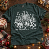 Who-Ville Christmas DTF transfer with white linework snowy village, decorated tree, crescent moon, stars, and the phrase 'where Christmas means a bit more' in cursive lettering Shown on a Blue Spruce t-shirt.