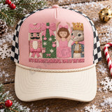 It's The Most Wonderful Time Of The Year DTF transfer with embroidery-style pink nutcracker, Christmas tree, ballerina, and crowned squirrel panels Shown on a blush pink front panel, cream bill, black-and-white checkered mesh back trucker hat.