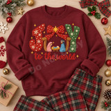 Joy to the World nativity DTF transfer with crochet-textured JOY lettering, red bow, gold star, and manger scene Shown on a Maroon crewneck sweatshirt.