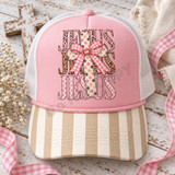 JESUS DTF transfer with pink leopard, giraffe print, and pink checkerboard lettering, layered with a wood-grain polka dot cross and pink gingham bow Shown on a blush pink front panel with ivory and tan striped bill and white mesh back trucker hat.