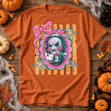 Cutesy horror DTF transfer featuring a spiral-cheeked puppet doll on a tricycle in a pink scalloped frame with bow and stars