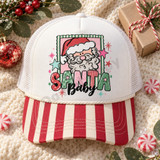 Santa Baby DTF transfer with retro cloud-bearded Santa face in a scalloped green and pink frame, bubble-lettered SANTA, black script Baby text, and scattered stars Shown on a white front panel with red and cream striped bill and white mesh back trucker hat.