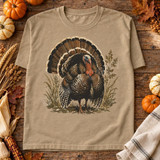 Vintage Wild Turkey DTF Transfer | Watercolor Thanksgiving Fall Design, tan T-shirt featuring a vintage watercolor wild turkey surrounded by autumn foliage, styled with pumpkins and fall decor on a rustic wooden table.