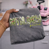 Mtn Dew Girlie DTF transfer with collage-style Mountain Dew can and bottle print letters and yellow-green script lettering on a gray shirt