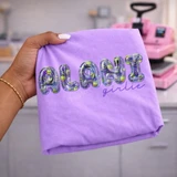 Drink Girlie DTF Transfers | Multiple Options, colorful purple and green drink-themed lettering transfer displayed on a lavender shirt beside a heat press