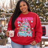 All Booked for Christmas DTF transfer featuring a Christmas tree made of colorful patterned books with pine branches, string lights, pinecones, and a pink plaid bow Shown on a Cardinal Red crewneck sweatshirt.