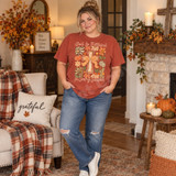 God Is Faithful In Every Season DTF transfer with rustic wooden cross, orange gingham bow, and autumn florals, pumpkins, and leopard-print accents Shown on a Brick t-shirt.