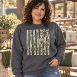 God Is Good All The Time DTF transfer with camo-print and leopard-print daisy flowers on a sage striped background Shown on a Graphite Heather crewneck sweatshirt.