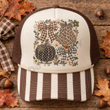 Farmhouse Fall Pumpkin & Bow DTF Transfer | Leopard & Gingham Autumn Design, rustic fall artwork featuring leopard-print and gingham pumpkins, plaid bows, flowers, and foliage displayed on a cream and brown trucker hat