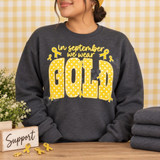 In September We Wear Gold DTF Transfer | Childhood Cancer Awareness Design, gold polka-dot lettering and awareness ribbons displayed on a charcoal sweatshirt