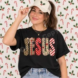 JESUS Christmas Patchwork DTF Transfer | Faith-Based Holiday Design, model wearing a black T-shirt featuring festive patchwork JESUS lettering in plaid, polka dot, floral, and striped Christmas patterns.