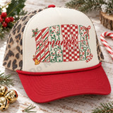 Christmas Mama DTF transfer with chunky block letters filled in candy-cane stripe, holly, checkerboard, and leopard patterns, topped with red cursive mama script and holiday bow, bell, and candy cane accents Shown on a cream foam front, red rope and bill, leopard mesh back trucker hat.