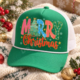 Merry Christmas DTF transfer with colorful patterned block letters, a Christmas tree replacing the E, gold star accents, scattered snowflakes, and red glitter-style script Christmas lettering Shown on a kelly green front panel, white mesh back, white rope trucker hat.