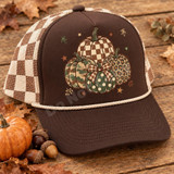 Patterned Pumpkin Stack DTF Transfer | Hand-Sketched Autumn Design, hand-sketched stack of patterned pumpkins in fall colors displayed on a brown and cream trucker hat among autumn leaves and pumpkins