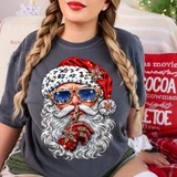 Hand-painted Santa Claus DTF transfer in jeweled sunglasses with snowy pine reflection, leopard print hat trim, and finger over lips in a shh pose