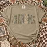 GRANDMA varsity letter DTF transfer with checkerboard, camo, leopard, polka dot, and floral patterns accented by cream bow ribbons Shown on a Khaki t-shirt.
