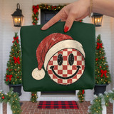 Retro red and cream checkered smiley face DTF transfer wearing a distressed Santa hat, printed on a green sweatshirt