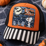 Halloween DTF transfer featuring a cartoon beagle holding a BOO! sign in a starry graveyard scene with a full moon, bats, tombstones, skulls, bones, and pumpkins Shown on a burnt orange front panel with black and white striped bill and black mesh back trucker hat.