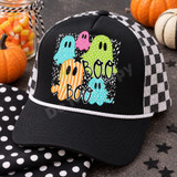 BOO Halloween DTF transfer featuring five patterned cartoon ghosts in teal, pink, green, and orange on a black and white speckled background with stars Shown on a black front panel with white rope and black-and-white checkered mesh back trucker hat.