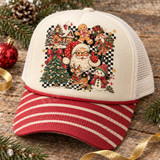 Christmas collage DTF transfer with winking Santa, gingerbread man, nutcracker, snowman, fawn, and cottage on a black-and-white checkerboard background with stars and snowflakes Shown on a Cream front panel with red striped bill and white mesh back trucker hat.