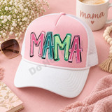 Playful graffiti-style MAMA DTF transfer in alternating pink, teal, and green hand-lettered letters with black outlines and white highlights Shown on a blush pink front panel with white pre-curved bill and white mesh back trucker hat.