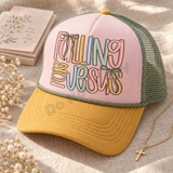 Falling for Jesus DTF transfer in bold hand-lettered multicolor typography with pastel blush, mustard, dusty blue, and sage tones, accented with sage green bow ribbons Shown on a Blossom front panel, mustard gold bill, sage green mesh back trucker hat.