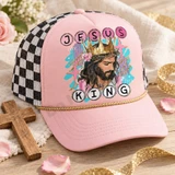 Jesus is King DTF transfer with painterly portrait of Jesus wearing a golden crown over a crown of thorns, teal brushstrokes, pink florals, and circle-letter text Shown on a Blush front panel, gold rope, black-and-white checkered mesh back trucker hat.