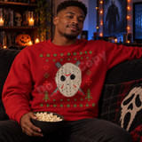 Hockey-mask skull DTF transfer in faux knit-sweater style with red scratch marks and crossed machetes, surrounded by holiday hearts, snowflakes, and trees Shown on a Cardinal Red crewneck sweatshirt.
