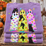 Three black cats with bat print, candy corn print, and polka dot ghost costumes surrounded by colorful stars DTF transfer design Shown on a Orchid t-shirt.