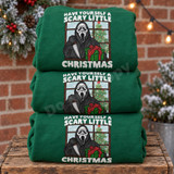 Have Yourself a Scary Little Christmas DTF transfer with Ghostface-style killer holding a knife and wrapped present at a snowy window with Christmas tree Shown on a Irish Green crewneck sweatshirt.