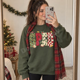 SPED frosted-cookie-lettering DTF transfer with leopard print, checkerboard, and mini Christmas tree patterns surrounded by candy cane, holly, paint palette, book, pencil and ruler doodles Shown on a Military Green crewneck sweatshirt.