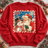 Vintage-style Christmas postage stamp DTF transfer featuring Santa Claus nuzzling noses with a plaid-scarved snowman under a starry night sky, framed by a candy-cane striped stamp border Shown on a Cardinal Red crewneck sweatshirt.
