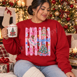 It's The Most Wonderful Time of the Year Christmas DTF transfer with pink ballerina, nutcracker soldier, decorated tree and pink polka-dot stripes Shown on a Cardinal Red crewneck sweatshirt.