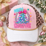 Merry Christmas DTF transfer with pastel swirled teal and pink Christmas tree, glittery pink bow, and scalloped medallion frame design Shown on a blush pink front panel, white bill, gold rope, leopard mesh back trucker hat.