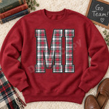 MI varsity letters DTF transfer in red, green, black and white tartan plaid with gray outline on a blue t-shirt Shown on a Antique Cherry Red crewneck sweatshirt.