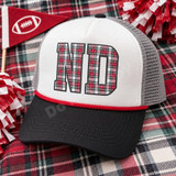 ND collegiate block letters DTF transfer filled with red, green, white, and black tartan plaid pattern and dark charcoal outline on a pink shirt Shown on a white front panel, black bill, grey mesh back, red rope trucker hat.