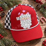 Whimsical Santa face DTF transfer with red polka-dot hat, curly white hair and beard, and pink cheeks in hand-drawn line art style Shown on a cardinal red front panel, white rope, black-and-white checkered mesh back trucker hat.