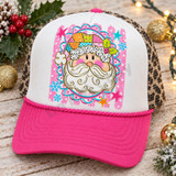 Whimsical Santa face DTF transfer with dotted fur trim, swirly beard, and patchwork hat inside a pink and teal scalloped frame Shown on a white front panel with hot pink bill and leopard mesh back trucker hat.