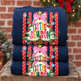Tis the Season DTF transfer with whimsical white flocked Christmas tree, pink gingham bow, gold star, and ornaments on a red polka-dot striped background Shown on a Navy crewneck sweatshirt.