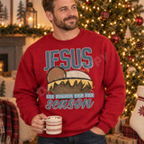 Jesus the reason for the season DTF transfer with bold vintage JESUS lettering and illustrated manger with baby Jesus in golden straw Shown on a Cardinal Red crewneck sweatshirt.