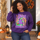 Treat Yourself Halloween DTF transfer with a green alligator dressed as a witch in a purple hat and cloak, holding a broom and jack-o-lantern pail, framed by orange stars on a retro striped background Shown on a Purple crewneck sweatshirt.