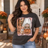 Trick or Moo Halloween DTF transfer featuring a highland cow in a ghost costume holding a glowing jack-o'-lantern bucket, with retro orange and brown striped background, bats, and stars Shown on a Pepper t-shirt.