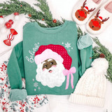 Believe Santa DTF transfer with polka dot hat, pink bow, and snowflake accents on a green sweatshirt
