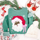 African American Santa face DTF transfer with pink polka-dot hat, pink bow, and sparkling snowflake accents on a green sweatshirt